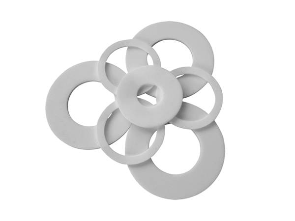 Some PTFE gaskets with different sizes on a white background.